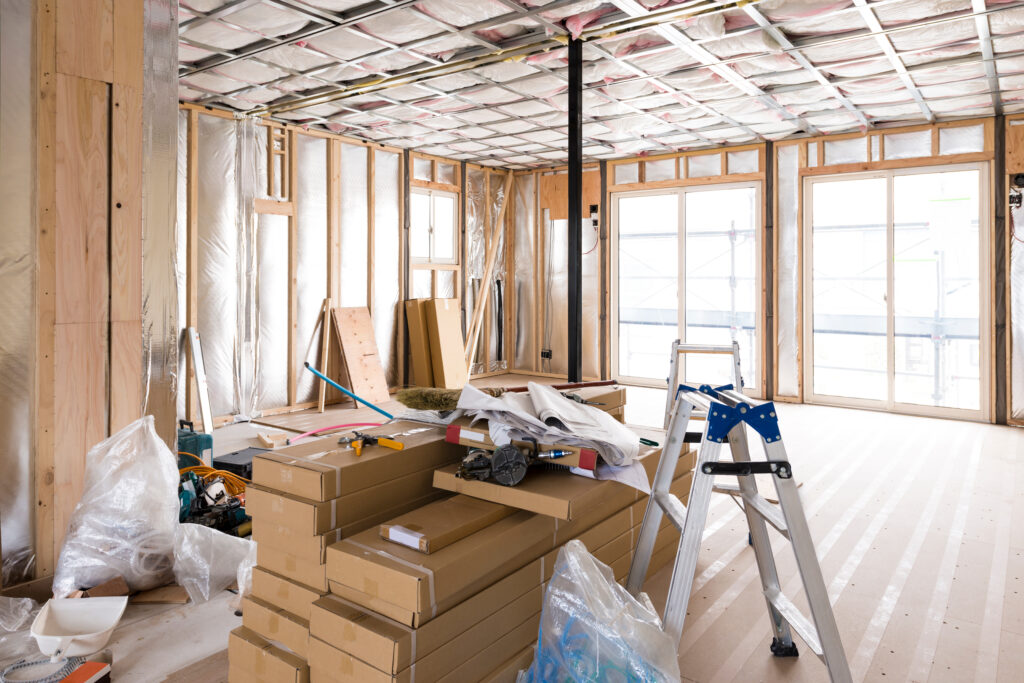 内装工事中の部屋に積まれた建材の箱と脚立