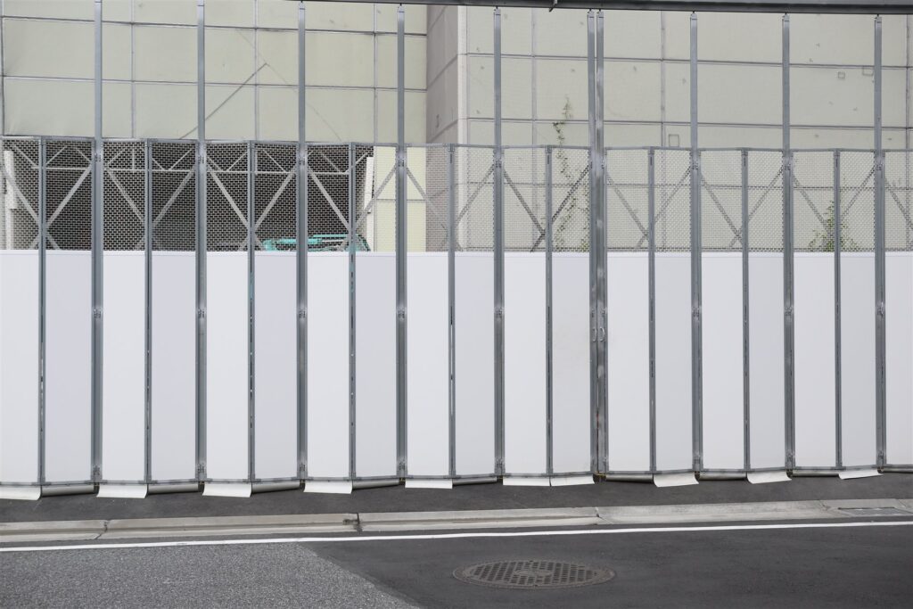 白い仮囲いに囲まれた都市の工事現場