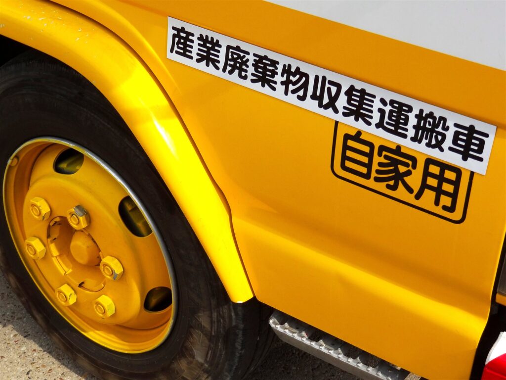 「産業廃棄物収集運搬車」の表示のある車体