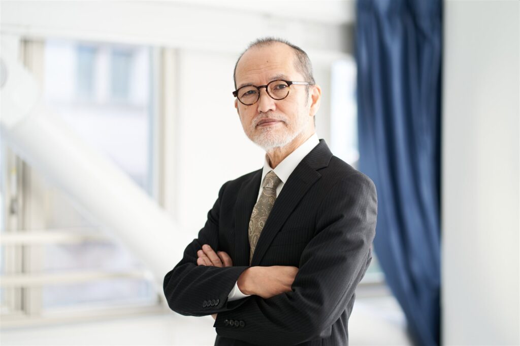 腕を組む眼鏡の年配の男性