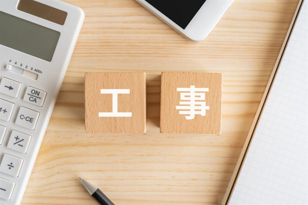 「工事」の積み木と電卓とスマートフォン