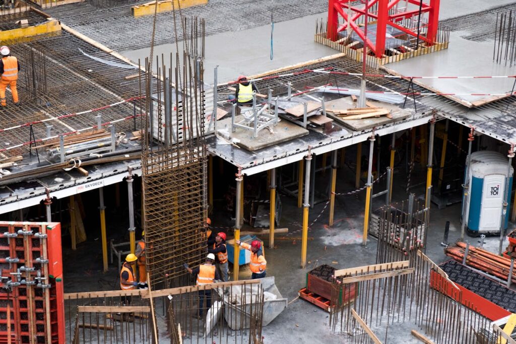 建設現場で鉄骨の組み立て作業に従事する複数の職人たち