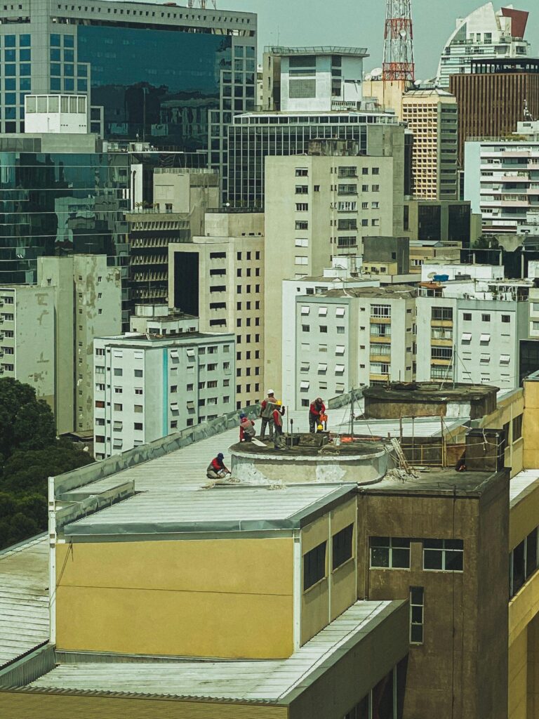 高層ビルが密集する都市部で作業する建設作業員。狭小地活用の現場イメージ