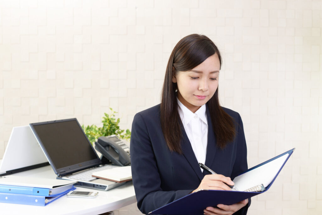ファイルを開いて予定を確かめる女性