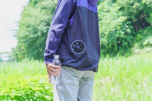 ファン付きウェアを着てペットボトルの水を持つ人の胴