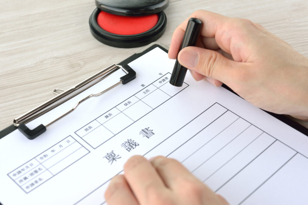 書類の申請の欄に判を押す手元