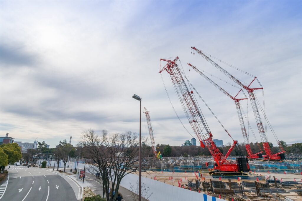 名古屋城の見える工事現場に並ぶ赤いクレーン