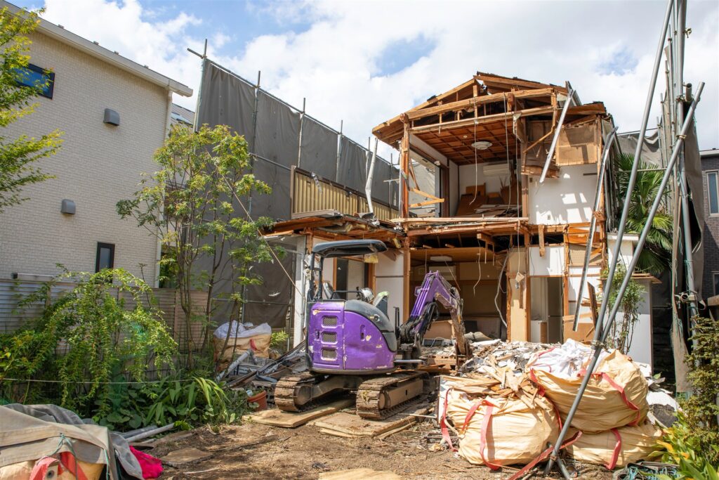 住宅街で小型の重機が木造の家を解体する現場
