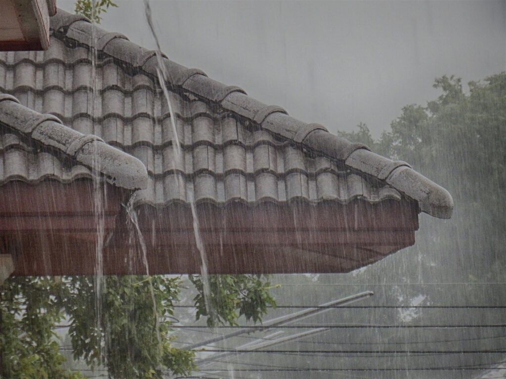 瓦屋根から流れ落ちる大雨