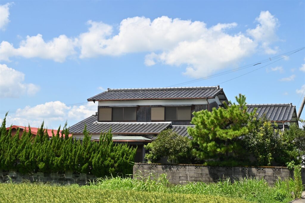 生け垣の向こうに建つ瓦屋根の日本家屋