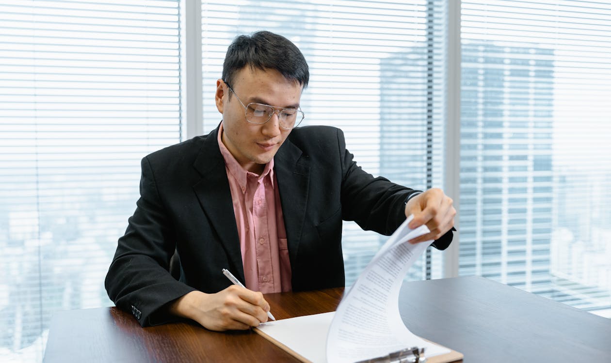 建設業許可の申請書類にサインする様子