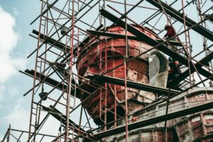 Workers on scaffolding during statue construction, showcasing building process.