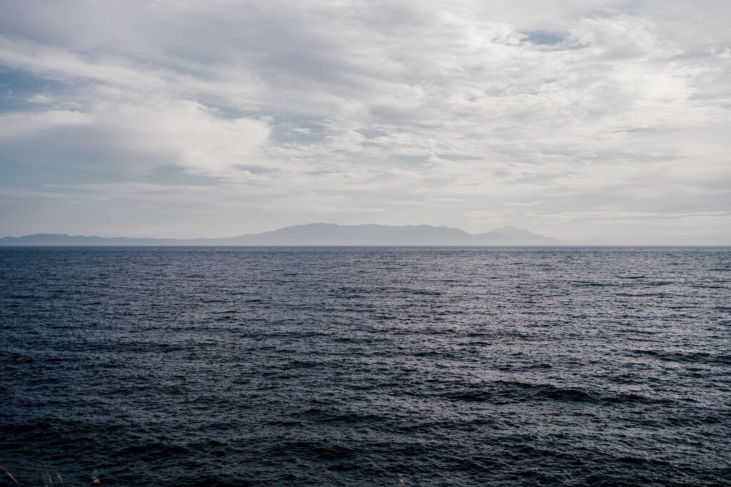 遠くに島影が浮かぶ波立つ海
