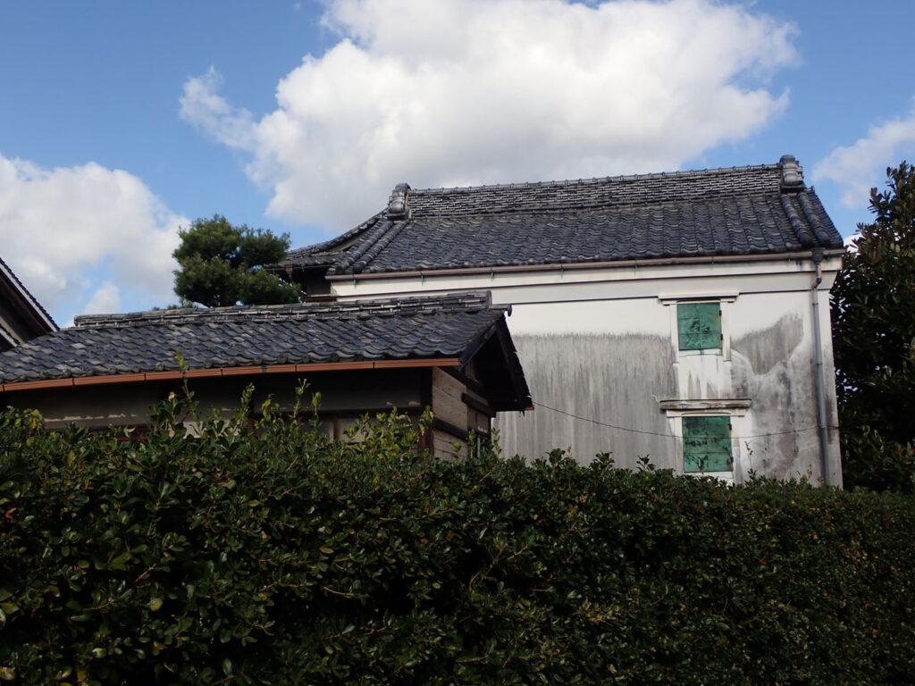 生け垣の向こうの瓦屋根の蔵