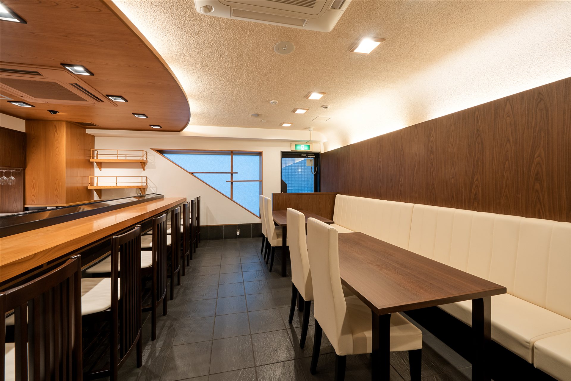 カウンターとテーブル席が並ぶ飲食店の内装