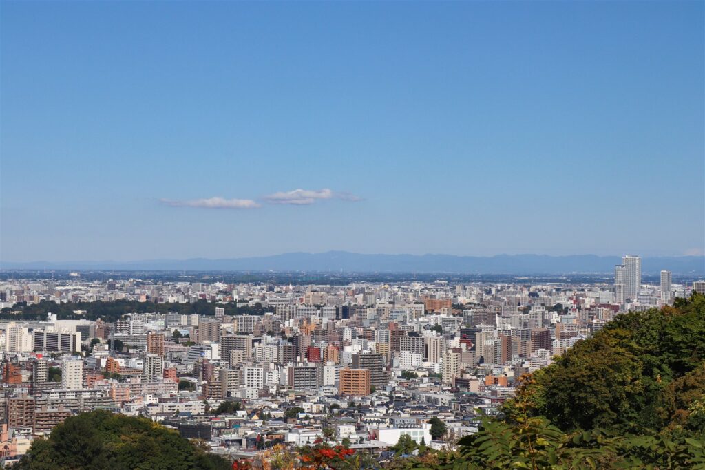 高台から見た札幌市の街並みと遠くの山