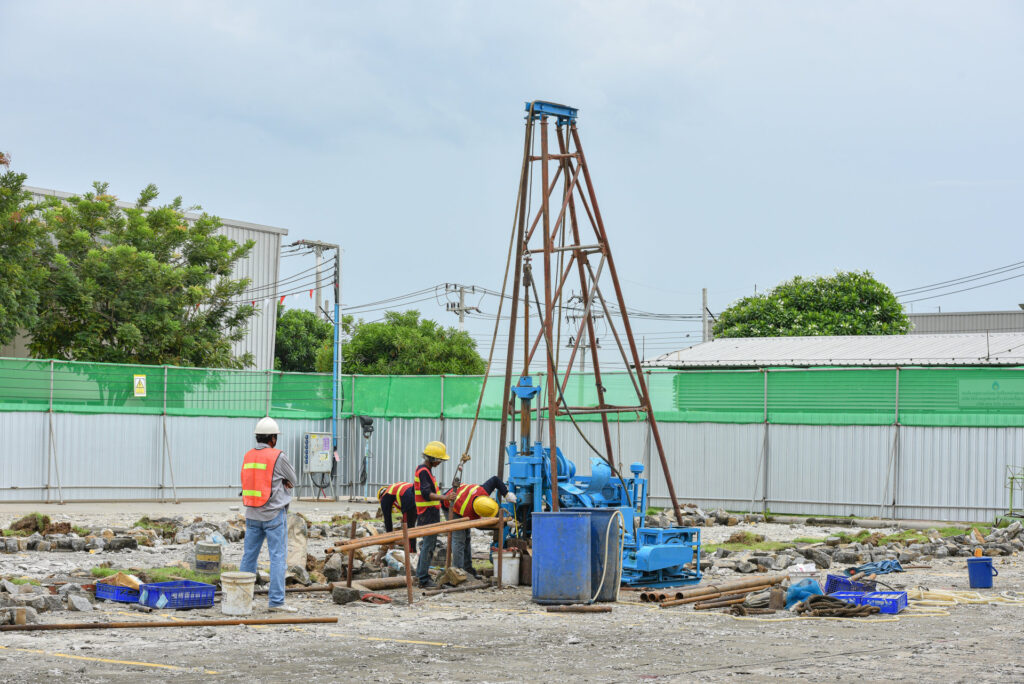 更地でボーリングの機械を使って地盤を調べる作業員たち