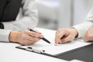 書類の項目をペンと指で確かめる手元