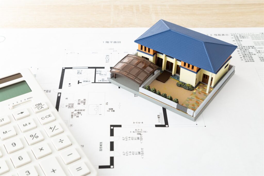住宅の模型と図面と電卓