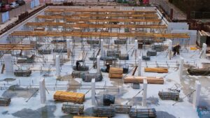 A busy construction site with scaffolding, steel structures, and workers.