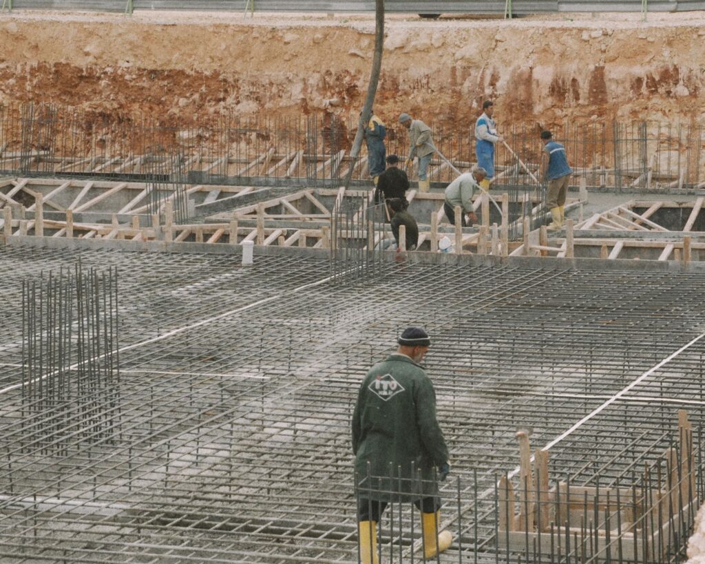 Workers building a foundation with rebar at a construction site.