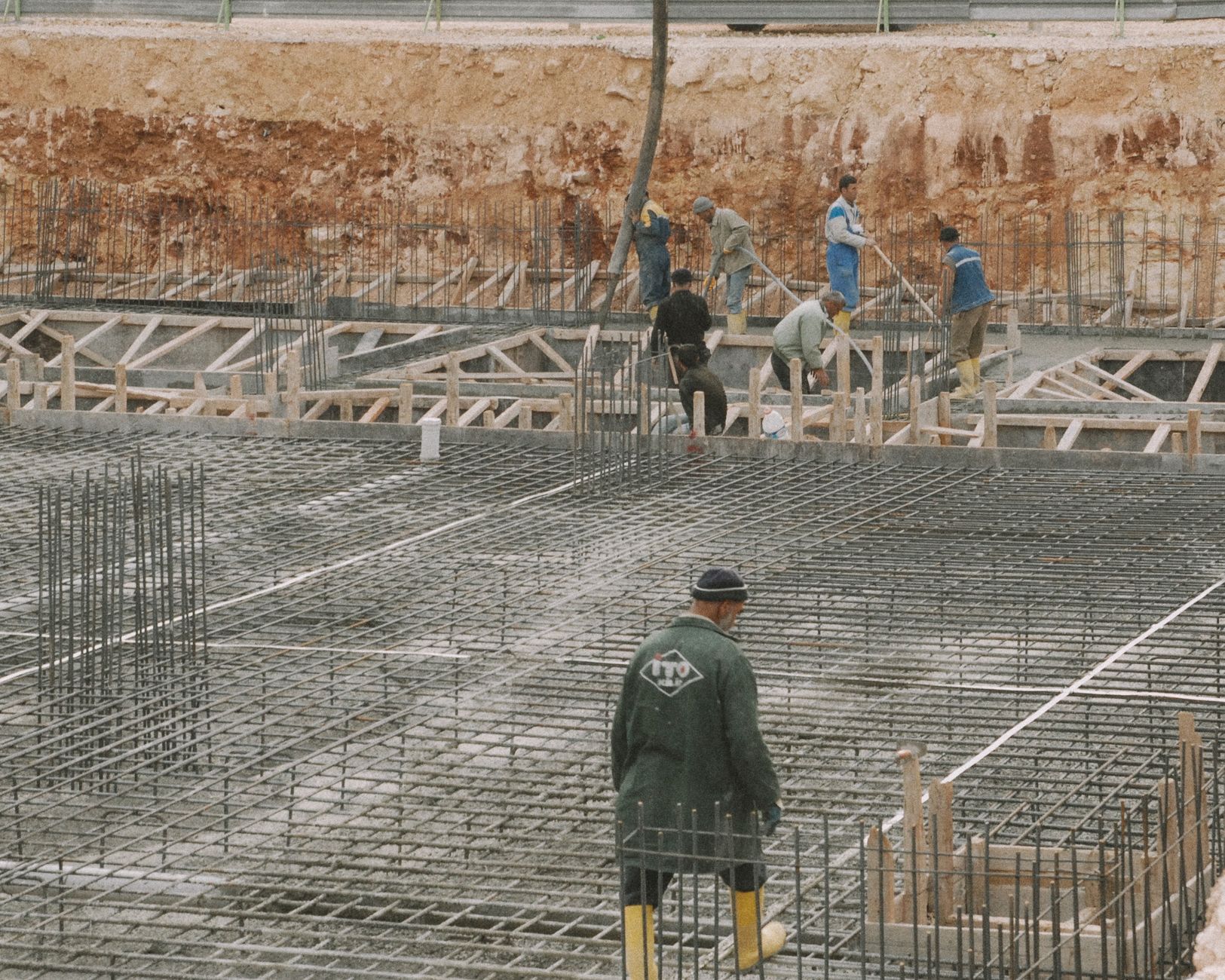 Workers building a foundation with rebar at a construction site.