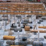 A busy construction site with scaffolding, steel structures, and workers.