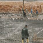 Workers building a foundation with rebar at a construction site.