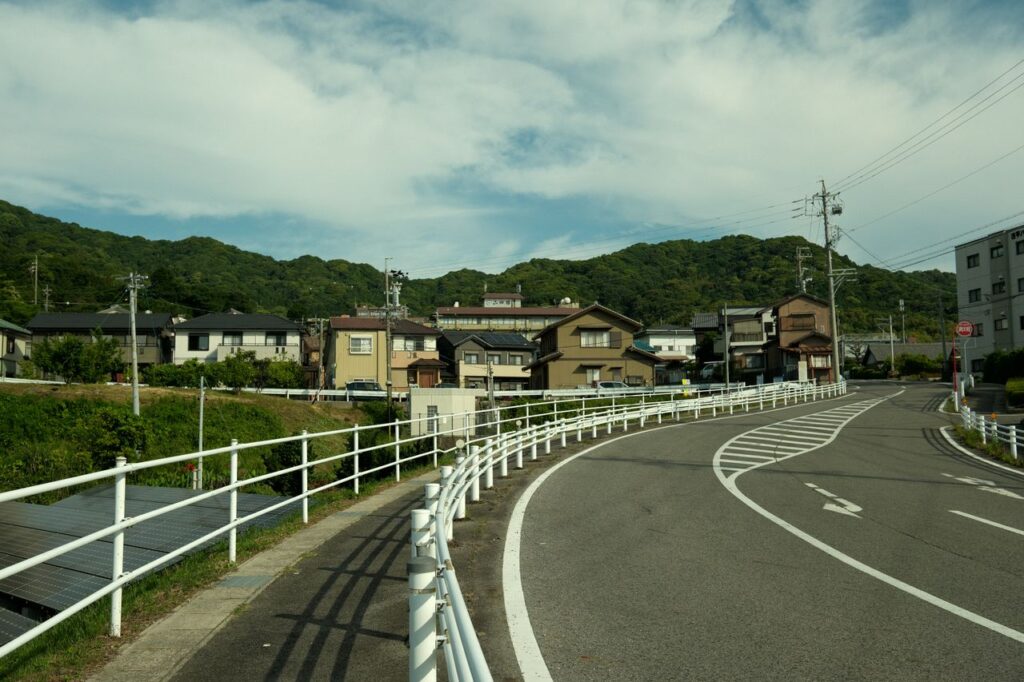 山を背にした住宅地と曲がる道路