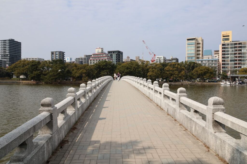 池に架かる白い石の橋と街並み