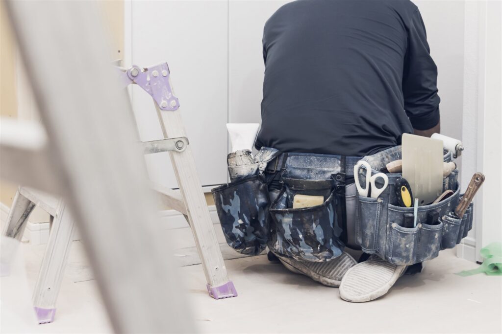 工具の腰袋を下げたクロスの職人の後ろ姿