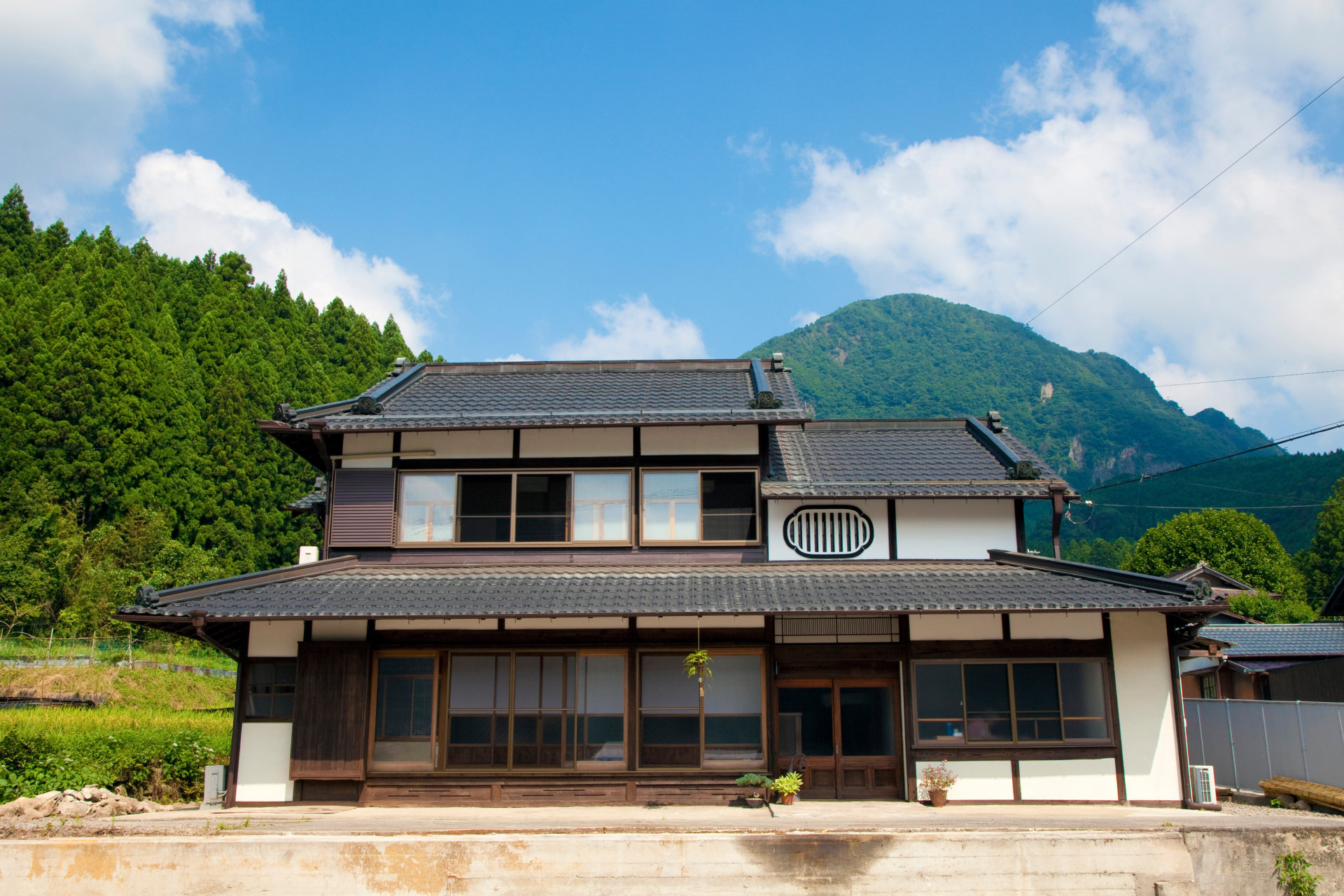山あいに建つ瓦屋根の古い日本の家