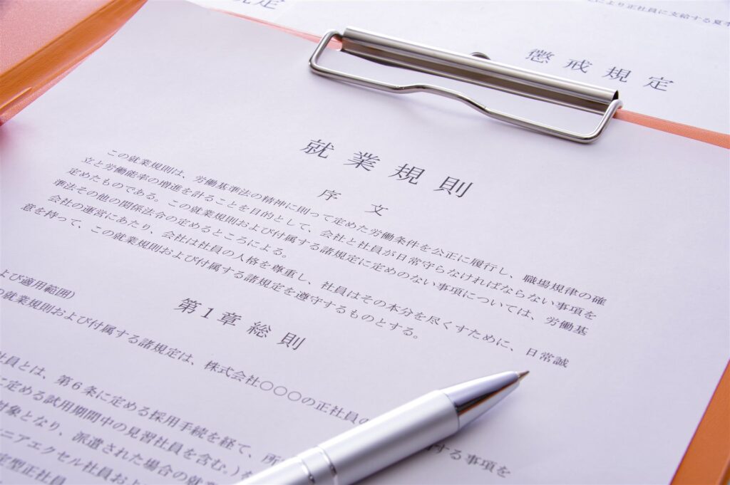 クリップボードに挟んだ就業規則とペン