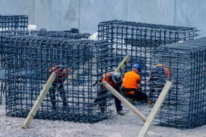 Construction workers assembling steel frames at a site, ensuring structural integrity.