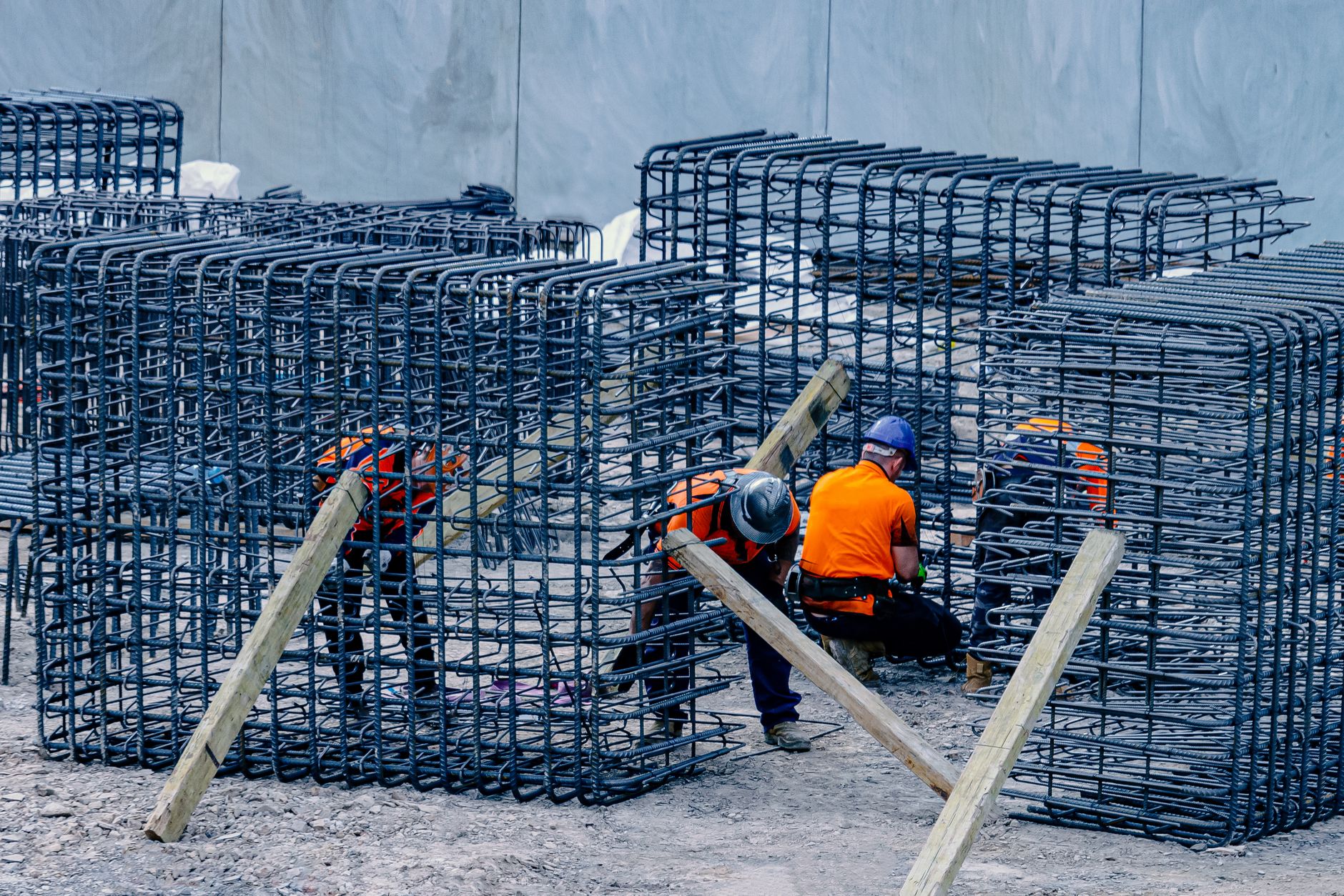 Construction workers assembling steel frames at a site, ensuring structural integrity.
