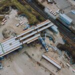 Aerial shot of an urban bridge construction site with machinery and infrastructure development.
