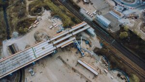 Aerial shot of an urban bridge construction site with machinery and infrastructure development.