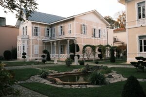 Charming Victorian-style house with manicured garden and beautiful pond.