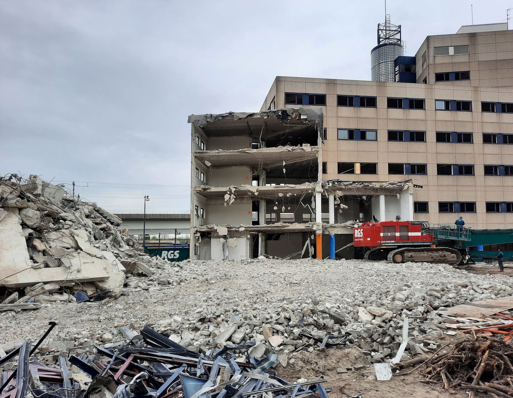 Urban building partially demolished with rubble and machinery.
