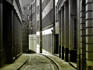 Monochrome street view showcasing vintage architecture in a narrow alleyway, creating a classic urban perspective.