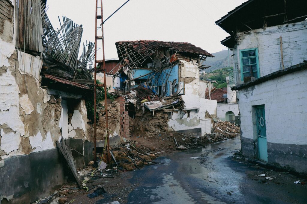 A devastated urban street in Malatya, Turkey after an earthquake, showcasing collapsed traditional houses.