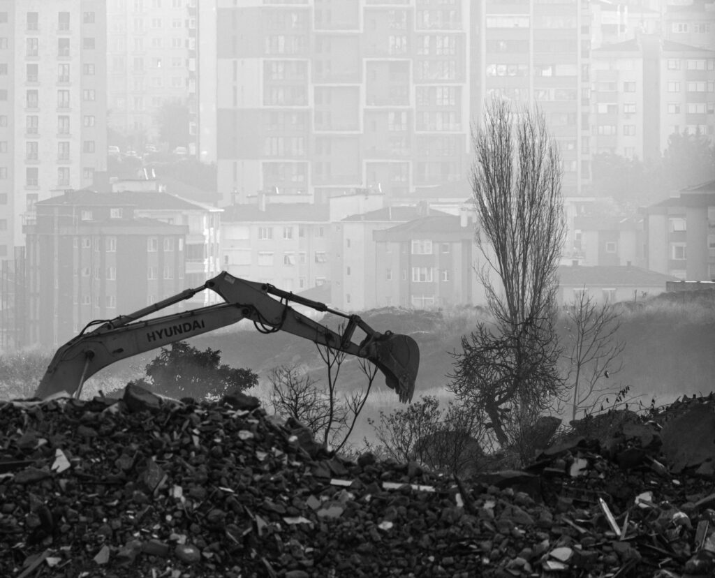 Monochrome view of urban excavation amidst foggy high-rises in İstanbul.