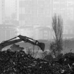 Monochrome view of urban excavation amidst foggy high-rises in İstanbul.