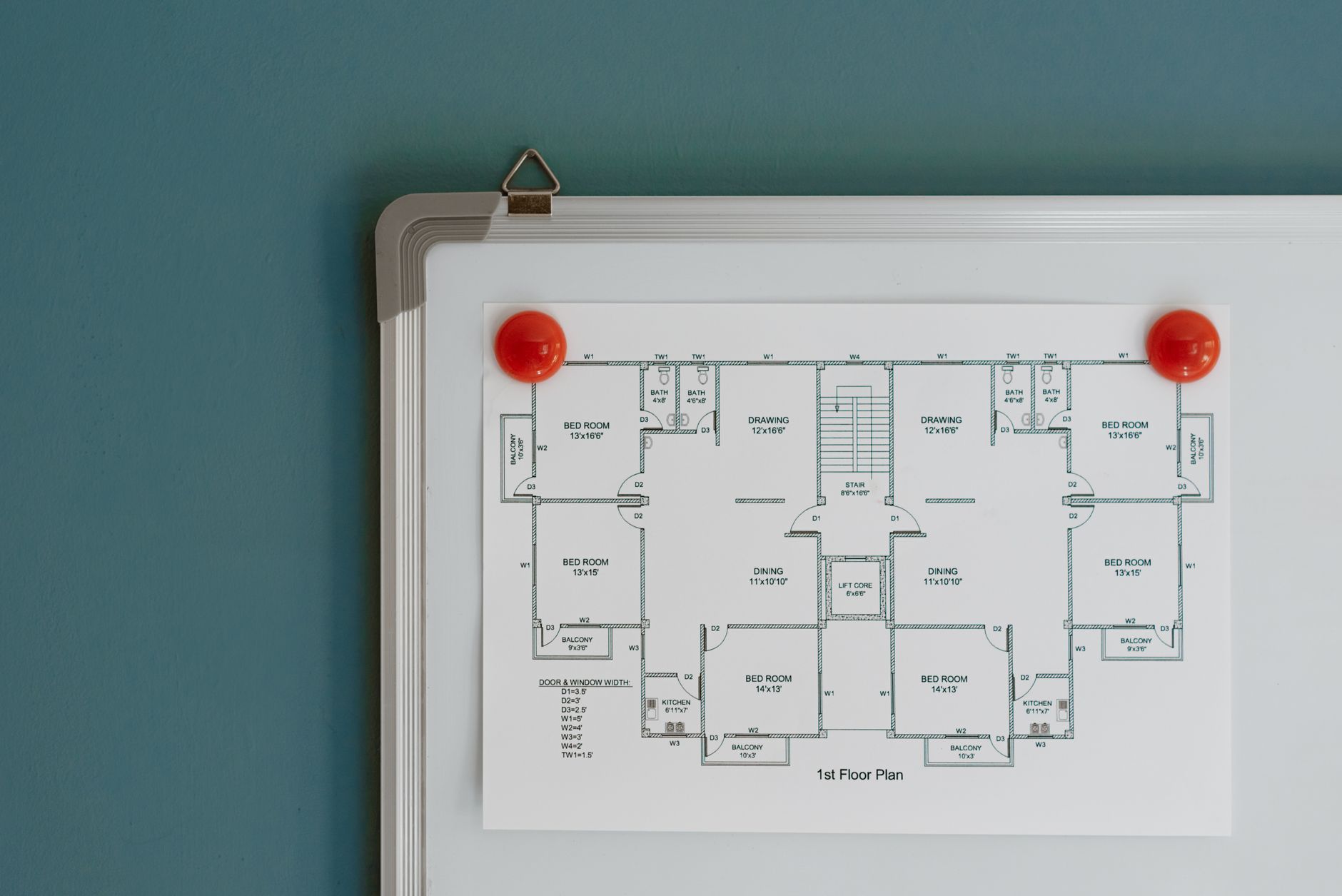 Architecture blueprint of floor in modern office on paper hanging on whiteboard with red magnets on colorful wall in room