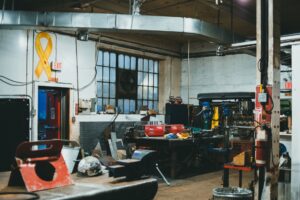 Interior of an industrial workshop featuring tools, machinery, and equipment in a busy work environment.