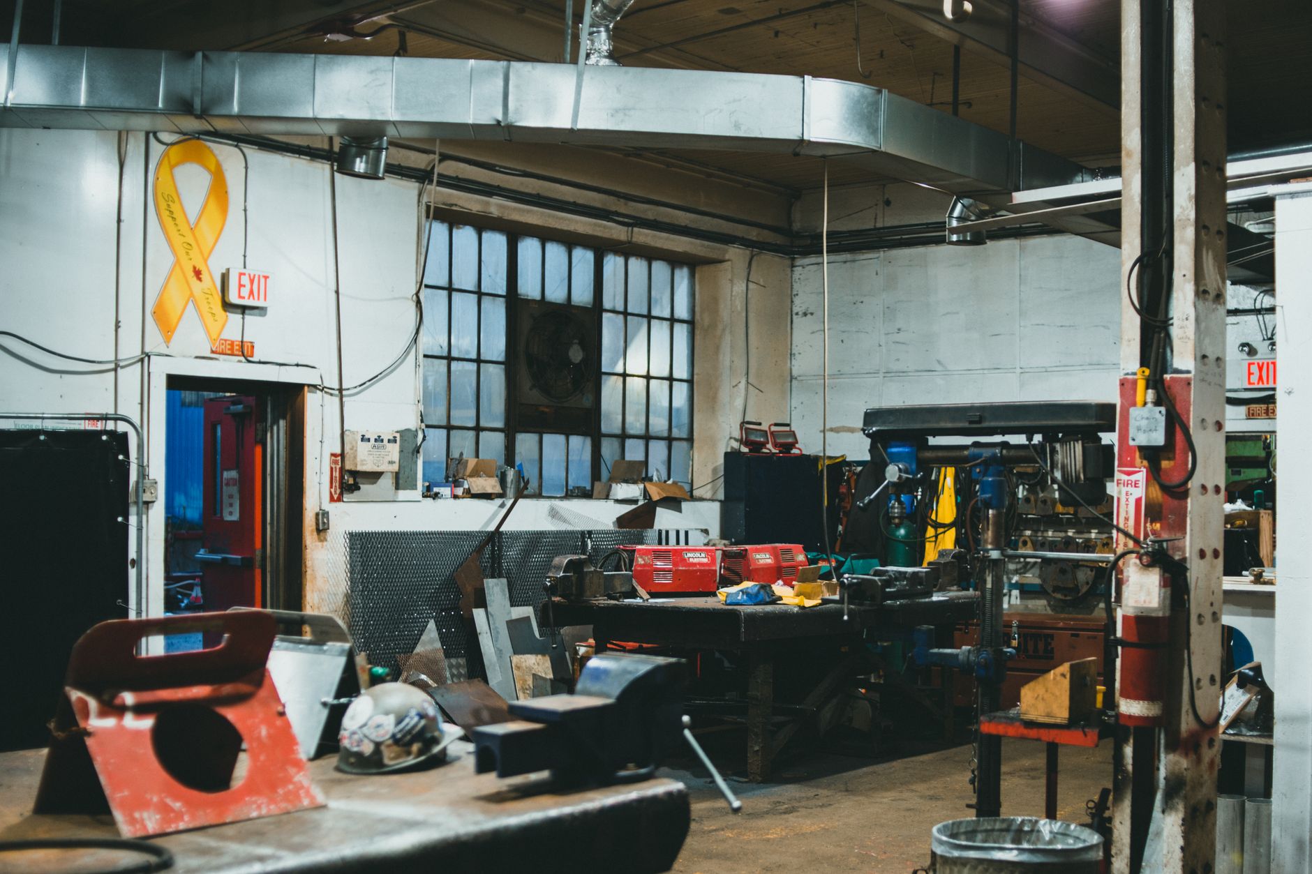 Interior of an industrial workshop featuring tools, machinery, and equipment in a busy work environment.