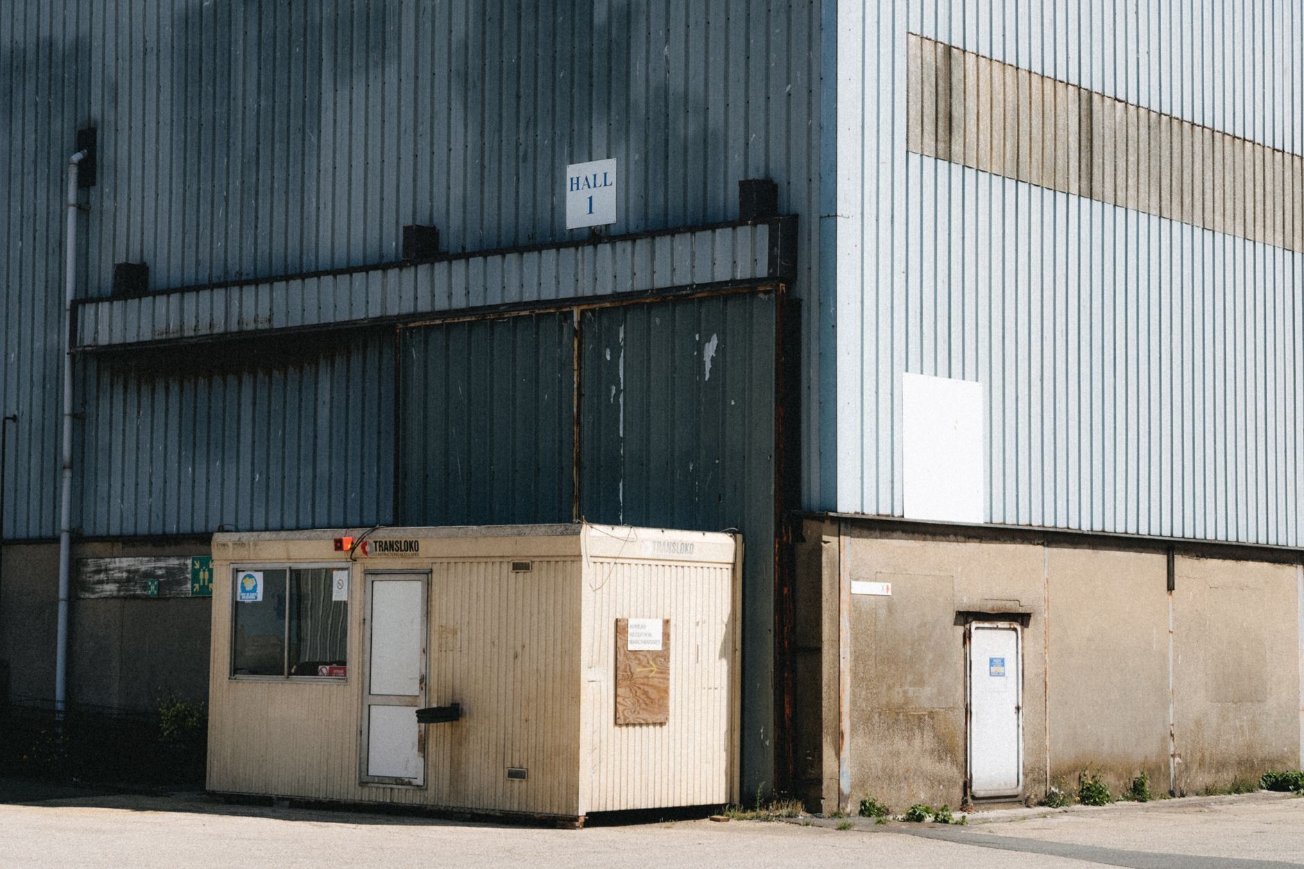 Outdoor view of a commercial warehouse with a small office in Dunkerque, France.