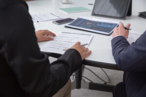Close-up of professionals reviewing documents in an office setting, focused on analytics.