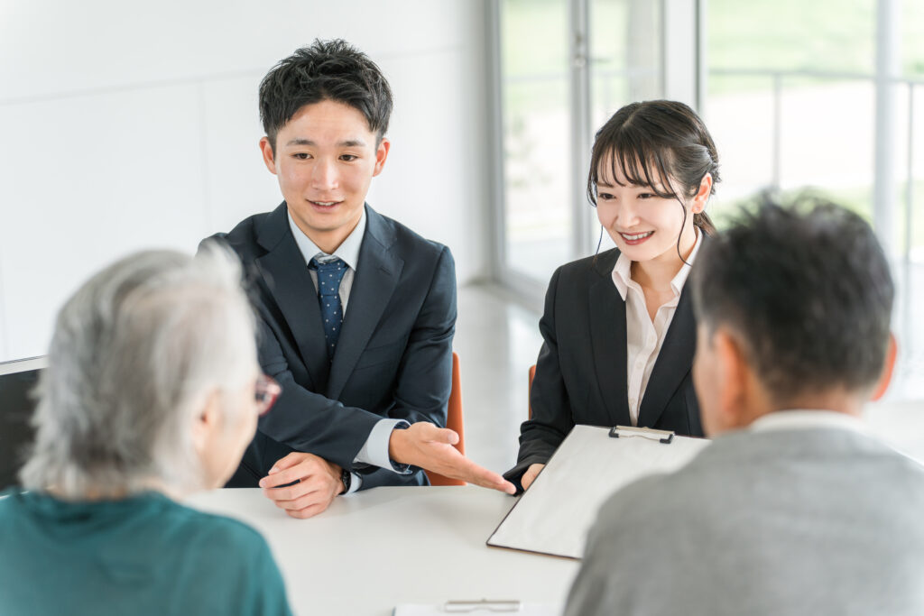 年配の夫婦に担当者が書類の中身を説明する