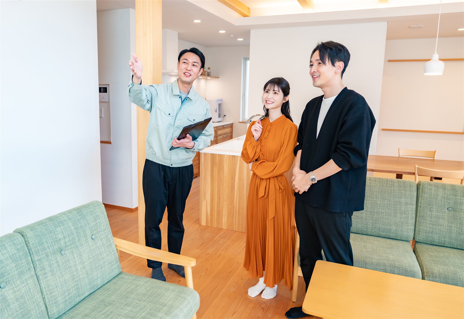 明るい室内で作業服の担当者が夫婦に説明する様子